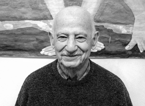 Black and white photo of Charles Garabedian in front of one of his paintings